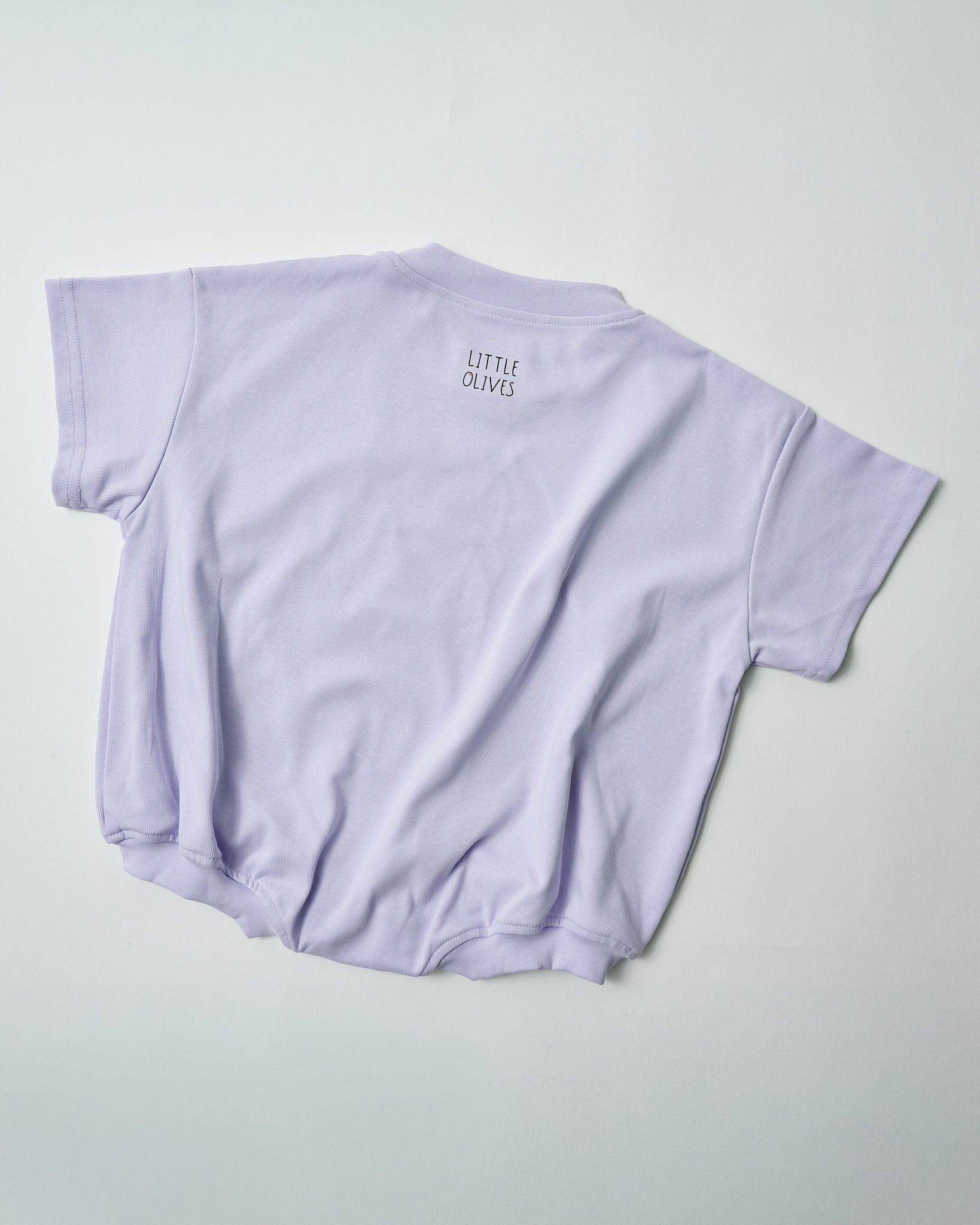 Back view of oversized lilac romper showing the relaxed, comfortable fit with Little Olives logo.