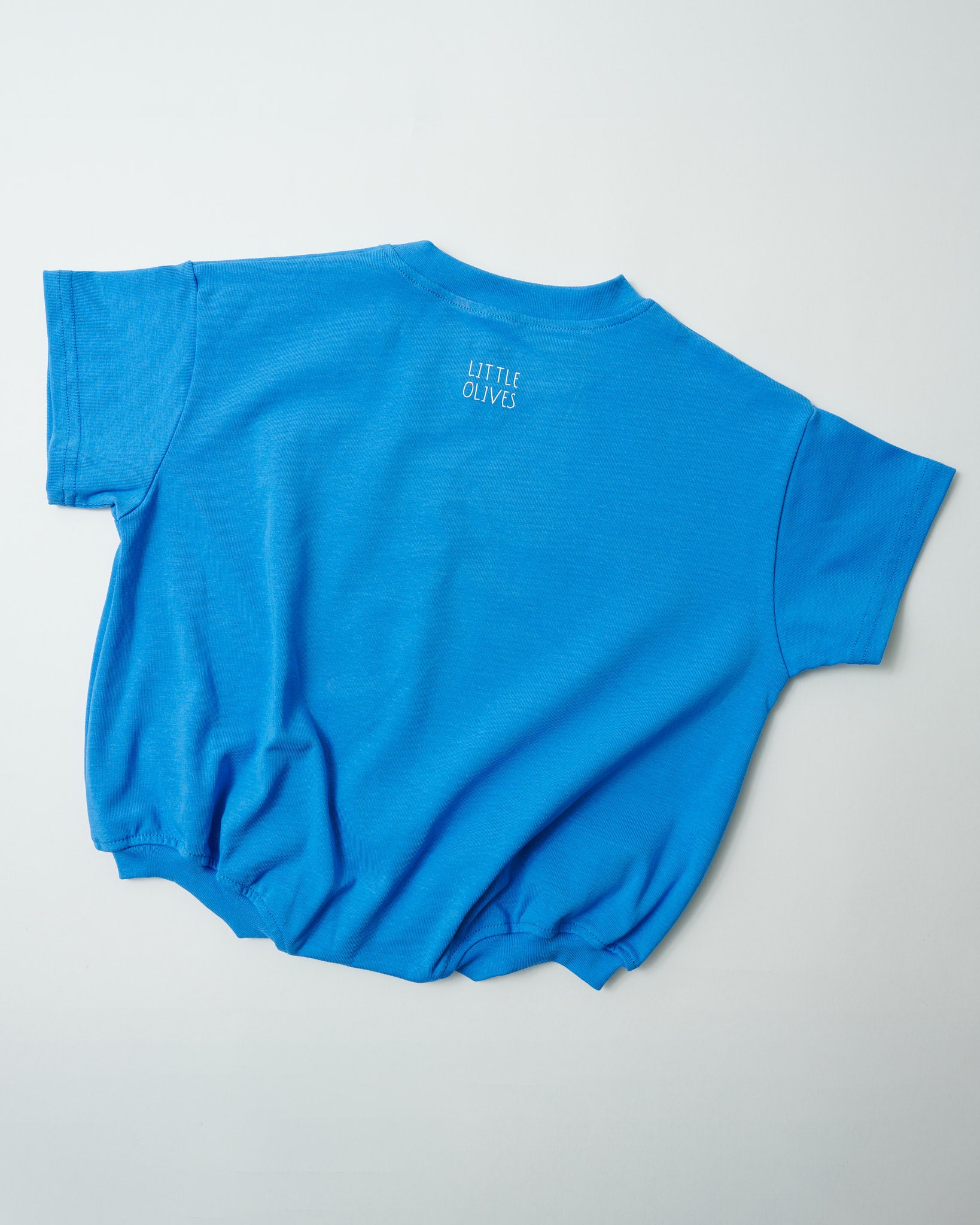 Back view of oversized sky blue toddler romper showing the relaxed, comfy fit.