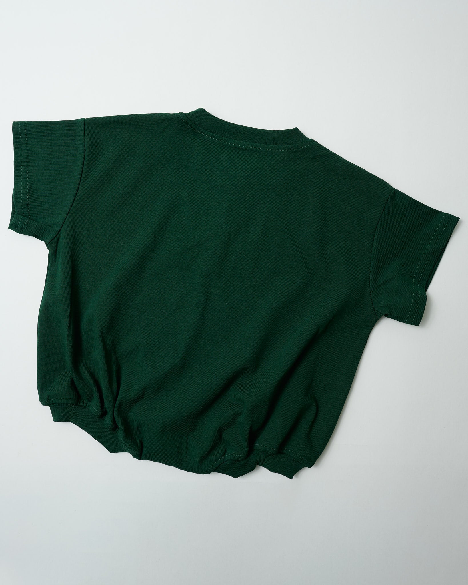 Back view of oversized forest green toddler romper showing the relaxed signature fit.