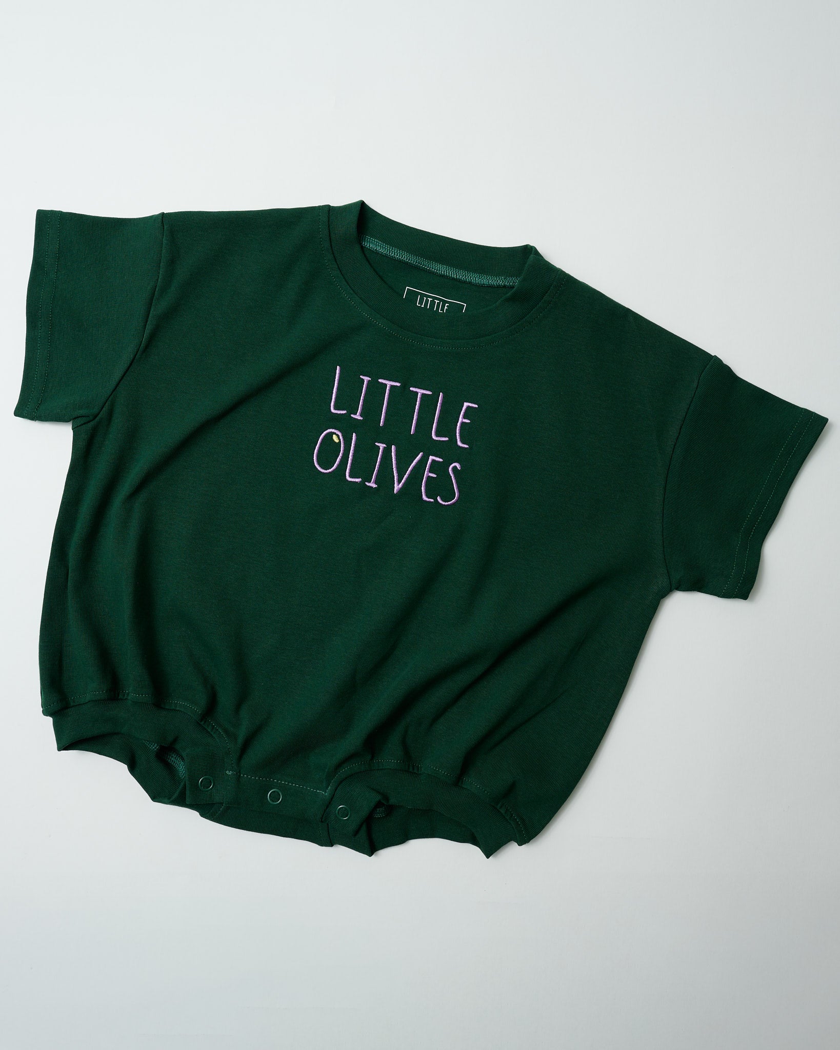 Front view of Little Olives forest green baby romper with light purple embroidery.