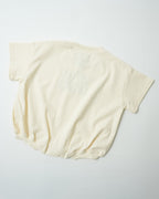 Back view of oversized organic cotton toddler romper in natural cream showing relaxed fit.
