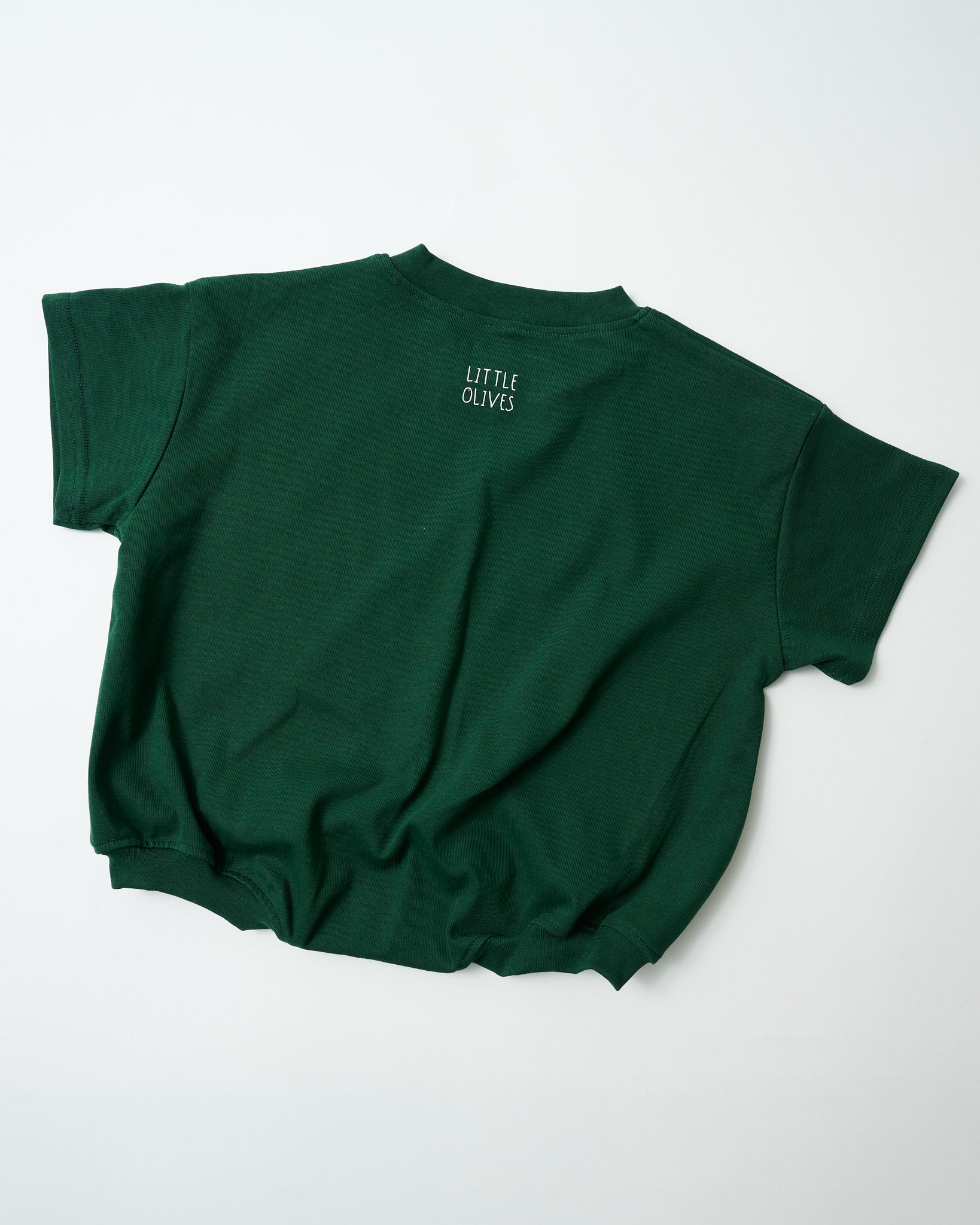 Back view of oversized forest green toddler romper showing the signature relaxed fit with Little Olives logo.
