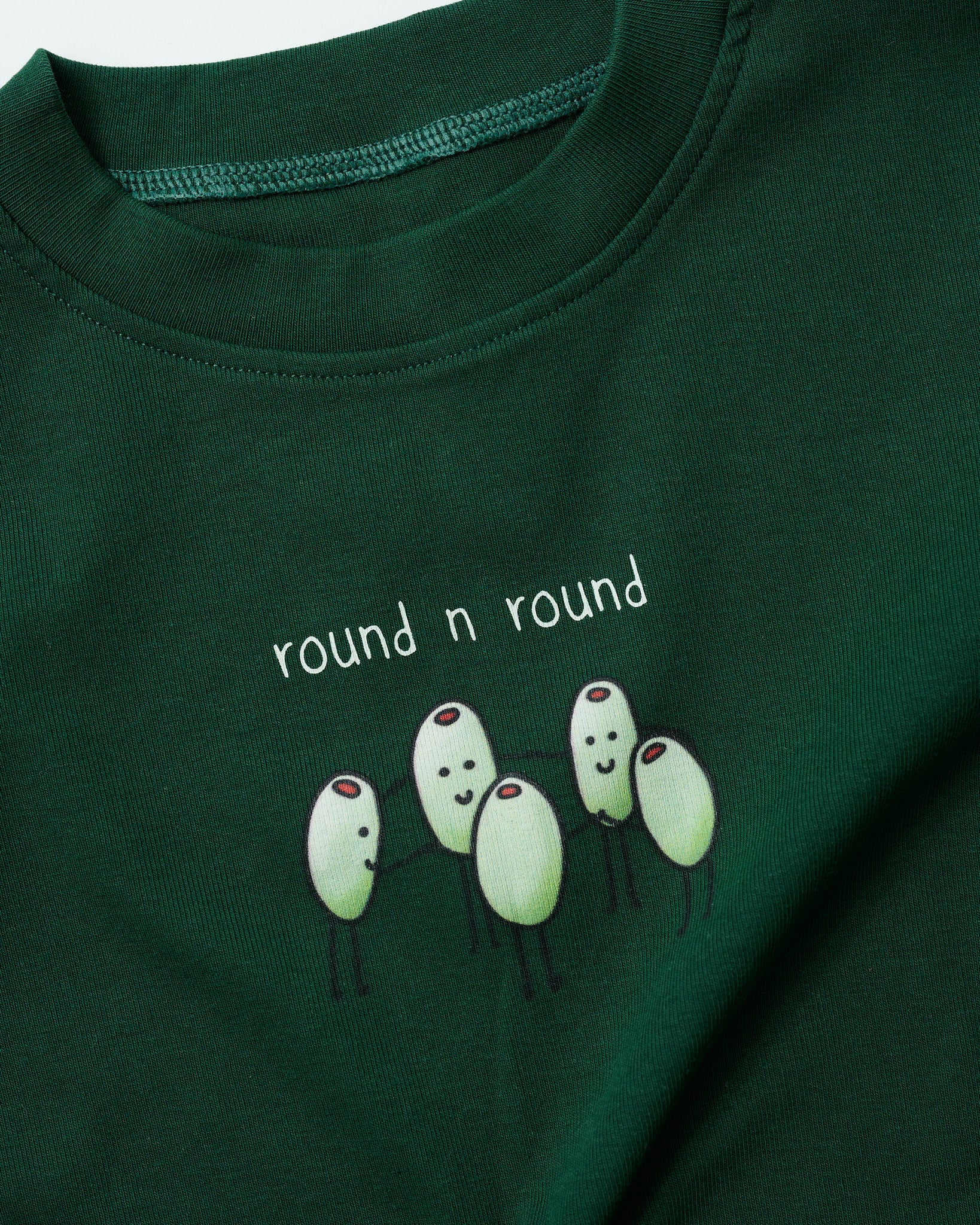 Detailed shot of the round-and-round olive digital print on textured forest green fabric.